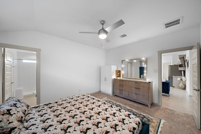 bedroom featuring freestanding refrigerator, visible vents, vaulted ceiling, and light colored carpet