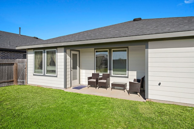 back of house featuring a yard, a patio area, roof with shingles, and fence