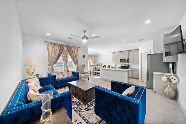 living area featuring light tile patterned floors, a ceiling fan, visible vents, and recessed lighting