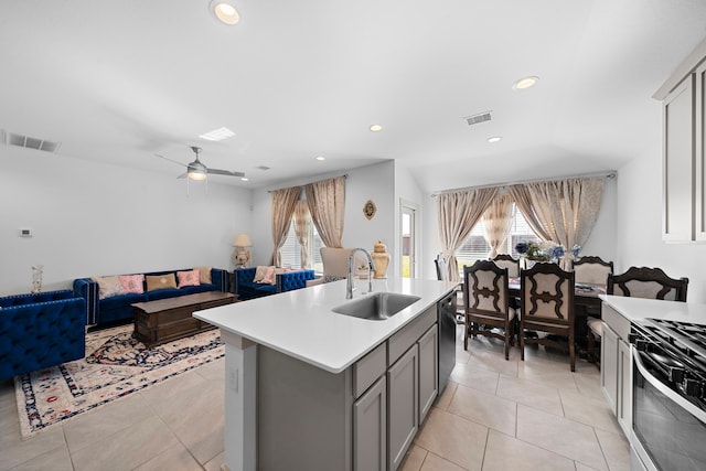 kitchen featuring visible vents, light countertops, a sink, and gray cabinetry