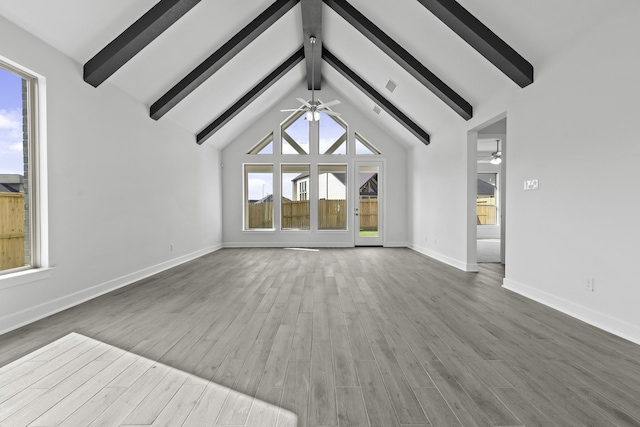 unfurnished living room featuring ceiling fan, beam ceiling, and wood finished floors