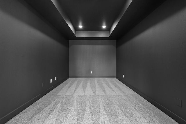 carpeted empty room with a raised ceiling and baseboards