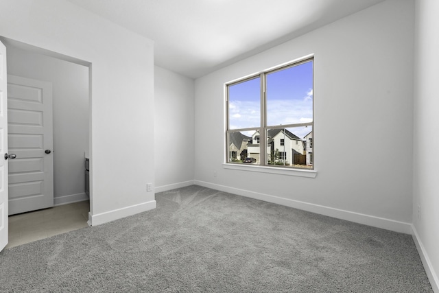 carpeted empty room with baseboards