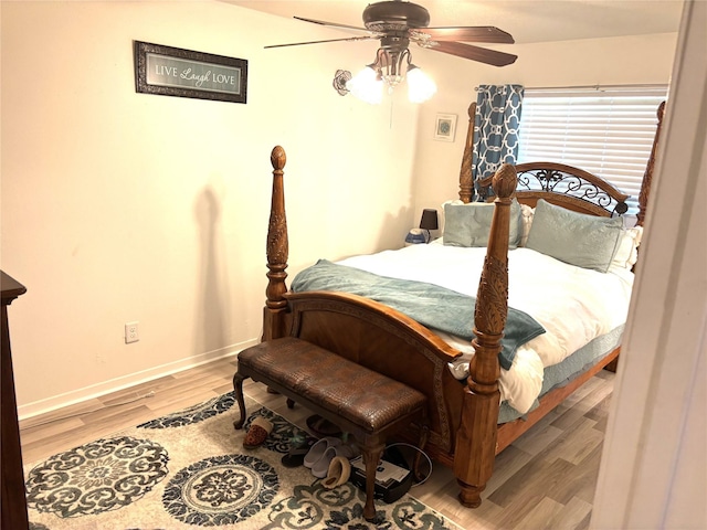 bedroom featuring ceiling fan, baseboards, and wood finished floors