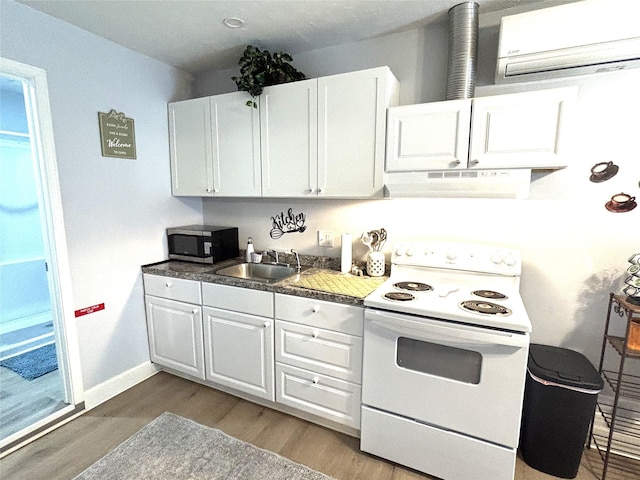 kitchen featuring a sink, ventilation hood, white range with electric stovetop, stainless steel microwave, and a wall mounted air conditioner