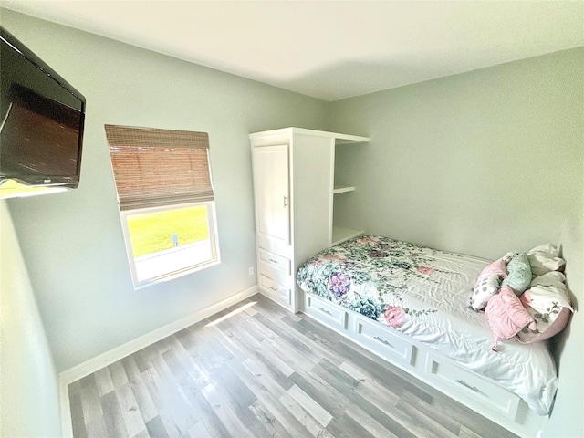 bedroom with baseboards and wood finished floors