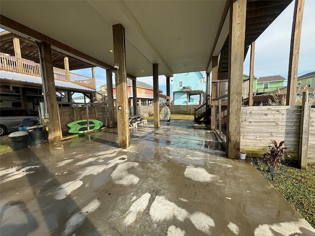 view of patio featuring fence and stairway