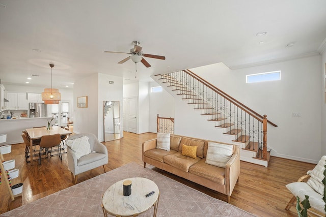 living area with ceiling fan, recessed lighting, baseboards, stairway, and light wood-type flooring