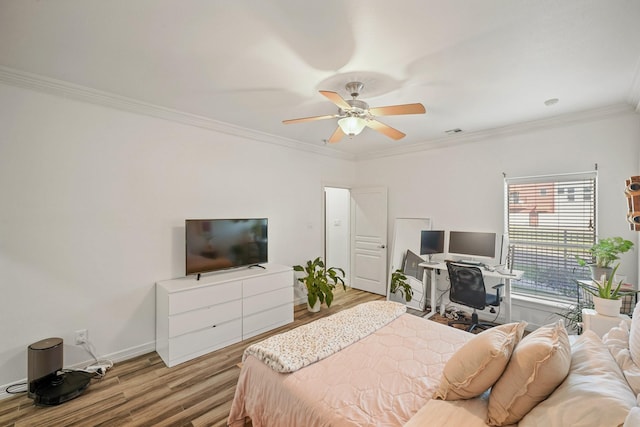 bedroom featuring a ceiling fan, crown molding, light wood-style flooring, and baseboards