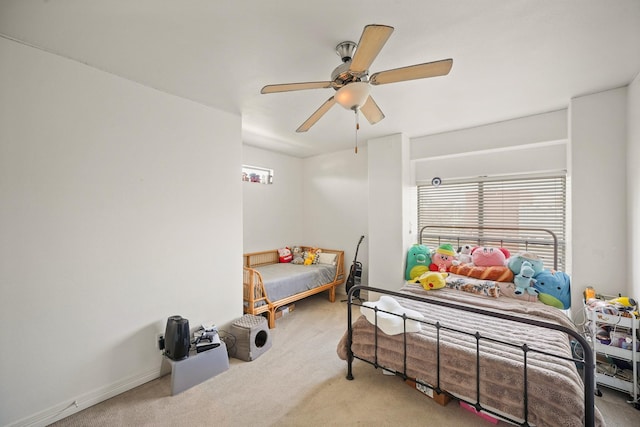 carpeted bedroom with ceiling fan and baseboards