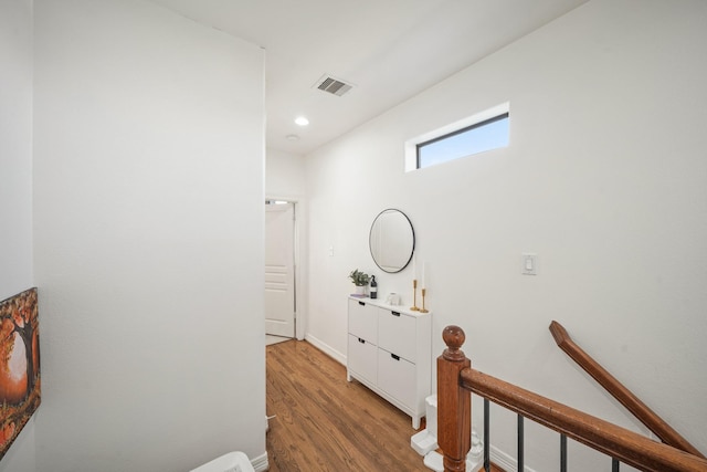 hallway featuring recessed lighting, visible vents, an upstairs landing, wood finished floors, and baseboards