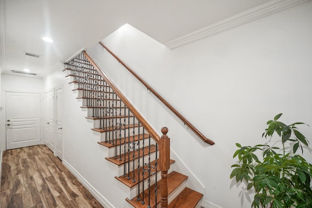 stairway featuring recessed lighting, wood finished floors, visible vents, baseboards, and crown molding