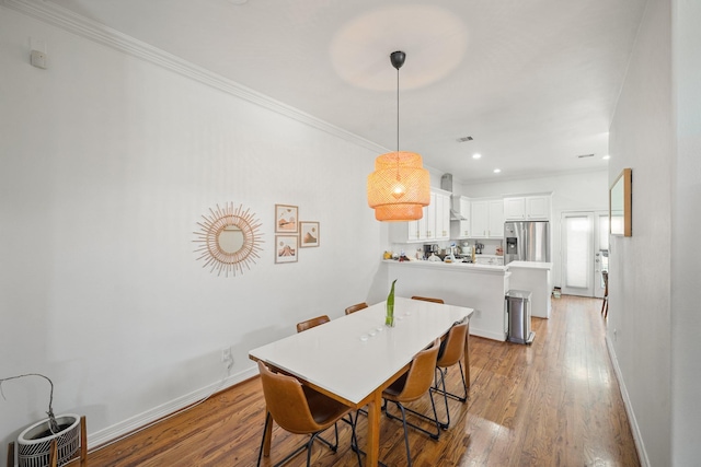 dining room with crown molding, recessed lighting, wood finished floors, and baseboards