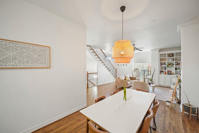 dining area with stairway, baseboards, and wood finished floors