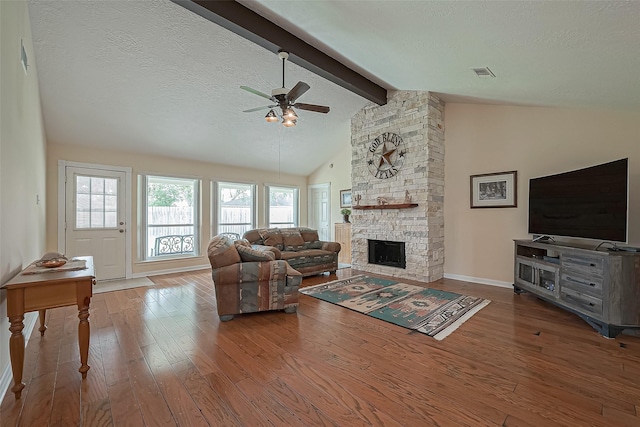 living area featuring a textured ceiling, beam ceiling, wood-type flooring, and visible vents