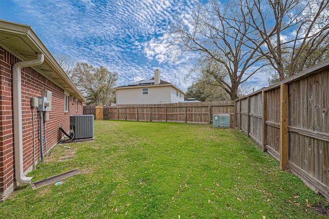 view of yard with central AC unit and a fenced backyard