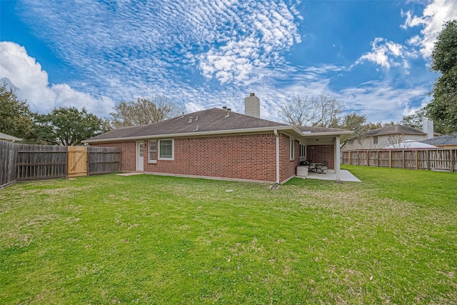 back of property with a patio area, brick siding, a fenced backyard, and a lawn