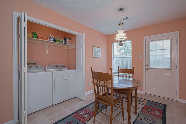 dining area featuring light tile patterned floors, washing machine and dryer, visible vents, and baseboards