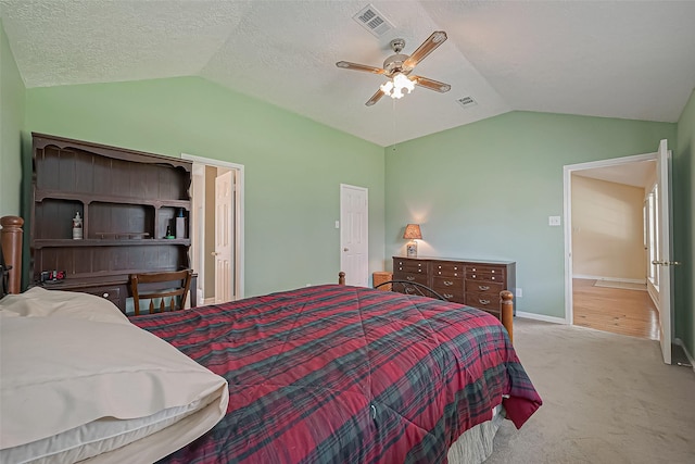 carpeted bedroom featuring baseboards, visible vents, vaulted ceiling, and a ceiling fan