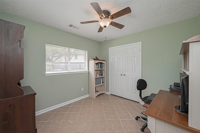 office featuring light tile patterned floors, visible vents, ceiling fan, a textured ceiling, and baseboards