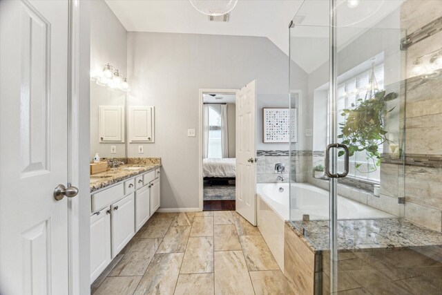 ensuite bathroom with a shower stall, vaulted ceiling, ensuite bathroom, a bath, and vanity