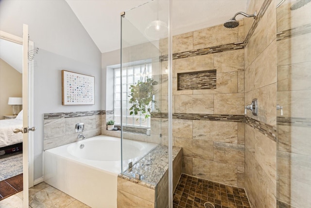 ensuite bathroom with vaulted ceiling, a bath, a shower stall, and connected bathroom