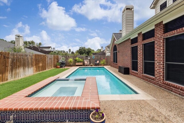 view of swimming pool with a patio, a fenced backyard, and a pool with connected hot tub