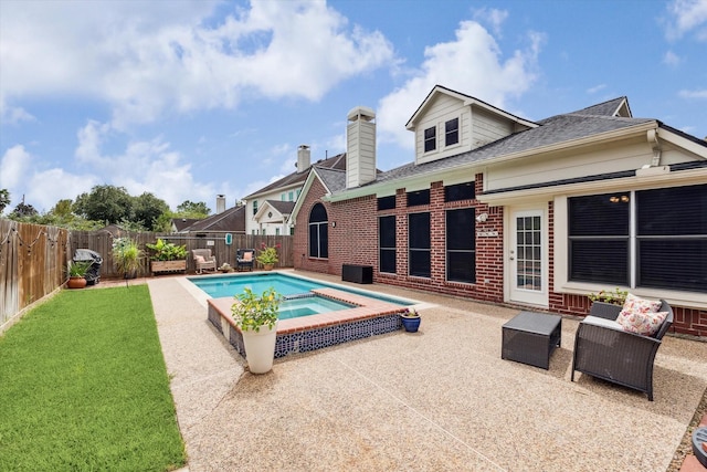 view of pool with a patio area, a yard, a pool with connected hot tub, and a fenced backyard