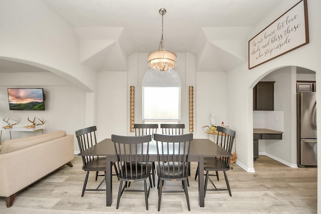 dining area with an inviting chandelier, light wood-style flooring, and baseboards