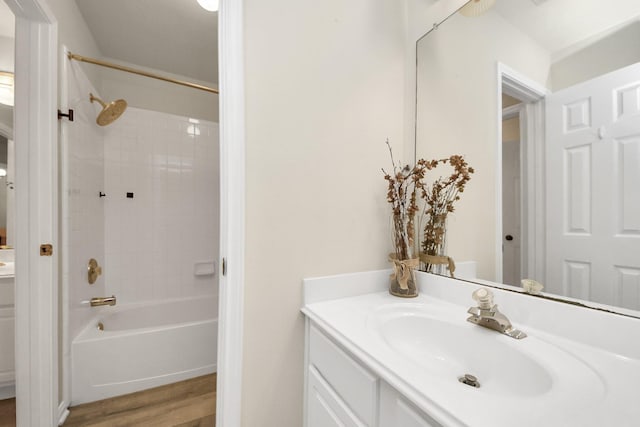 bathroom with washtub / shower combination, wood finished floors, and vanity