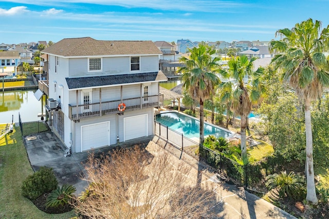 rear view of property with a garage, driveway, and a residential view