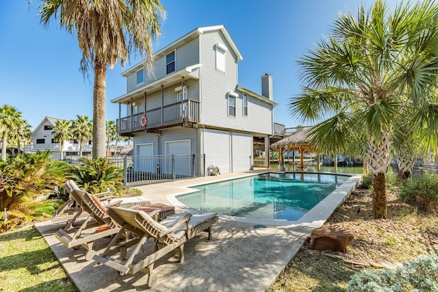 back of house with a patio, fence, a fenced in pool, and a gazebo