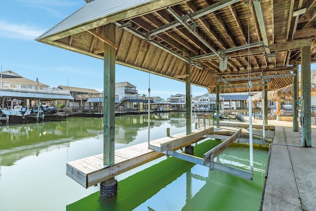 view of dock featuring a residential view, a water view, and boat lift