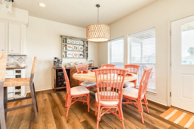 dining room with wine cooler, wood finished floors, and baseboards