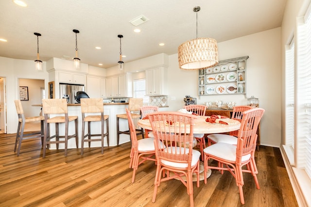 dining area with light wood-type flooring, visible vents, and recessed lighting