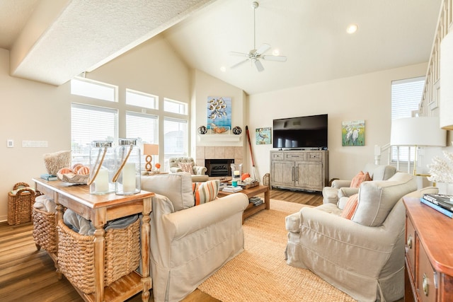 living room with recessed lighting, a tiled fireplace, a ceiling fan, wood finished floors, and high vaulted ceiling