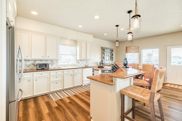 kitchen with light wood-style flooring, a sink, freestanding refrigerator, dishwasher, and tasteful backsplash