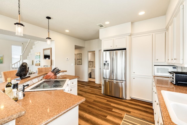 kitchen with white appliances, dark wood-type flooring, visible vents, and white cabinets