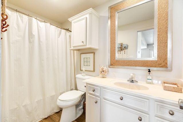 full bathroom with curtained shower, vanity, toilet, and wood finished floors