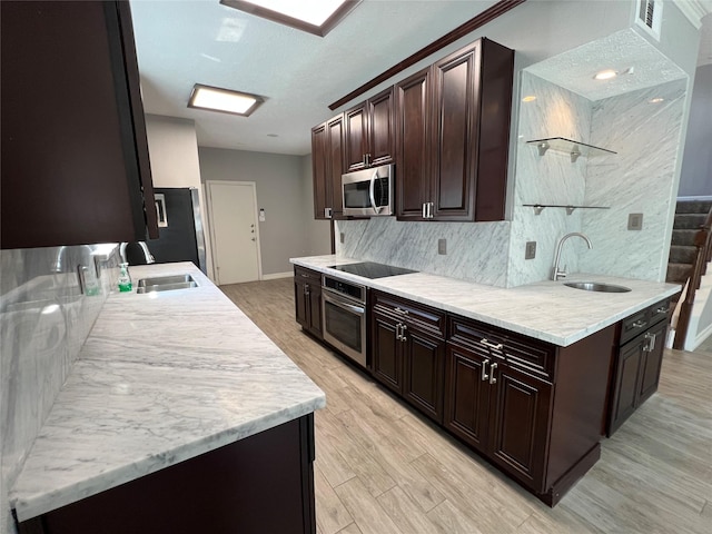 kitchen featuring black appliances, dark brown cabinets, and a sink