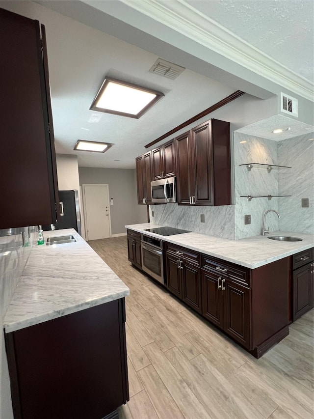 kitchen with stainless steel appliances, visible vents, a sink, and dark brown cabinets