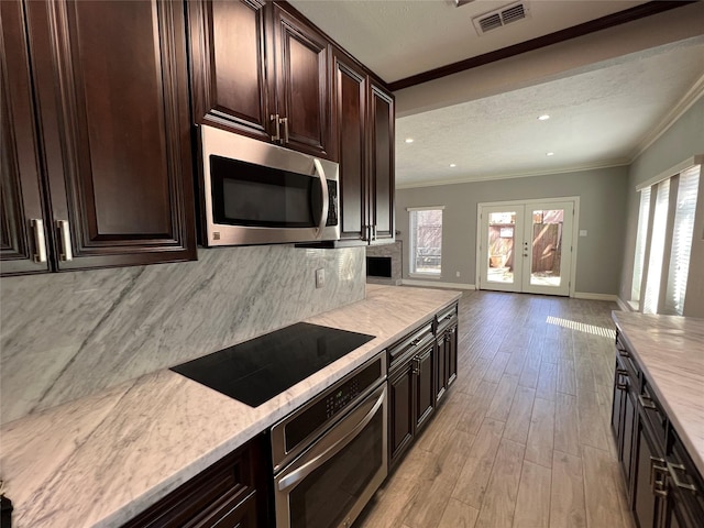 kitchen with stainless steel appliances, visible vents, open floor plan, ornamental molding, and french doors