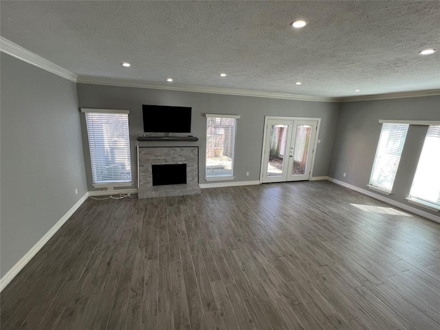 unfurnished living room featuring dark wood-style floors, ornamental molding, and plenty of natural light