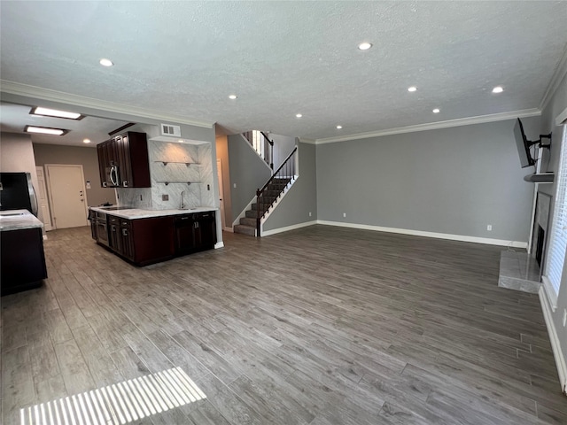 kitchen with a fireplace, light countertops, visible vents, open floor plan, and dark brown cabinetry