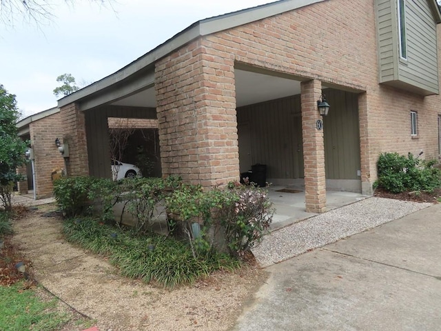 view of side of home featuring a garage and brick siding