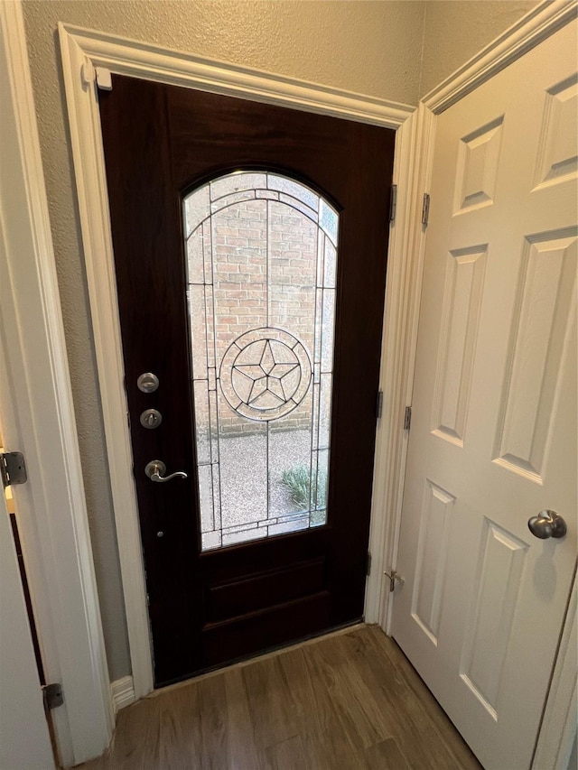 entryway with a textured wall and wood finished floors