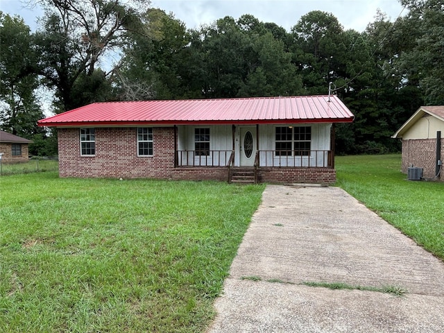 single story home featuring brick siding, central air condition unit, covered porch, a front yard, and metal roof