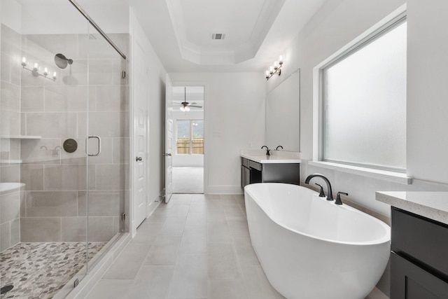 full bathroom with vanity, visible vents, a freestanding bath, a shower stall, and a tray ceiling