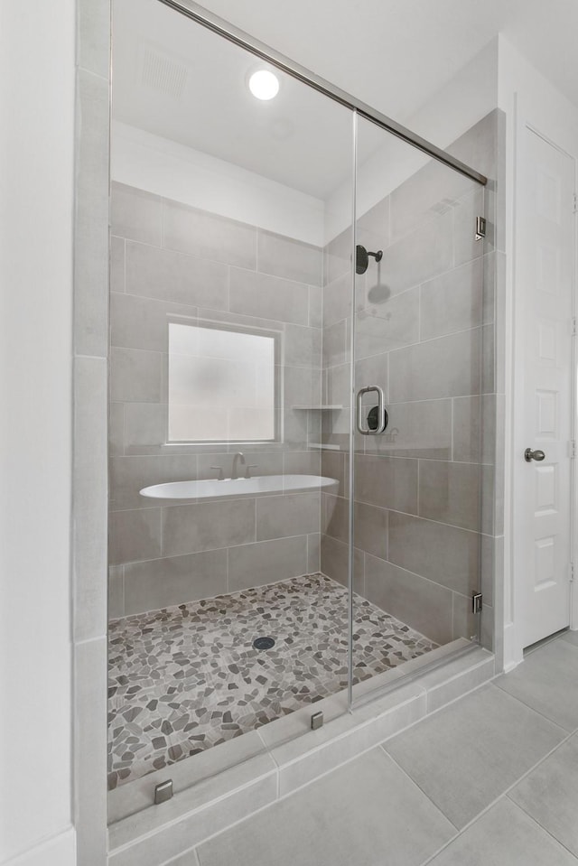 bathroom with a shower stall and tile patterned flooring