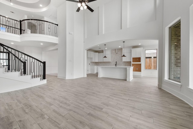 unfurnished living room featuring stairway, recessed lighting, a ceiling fan, and wood tiled floor